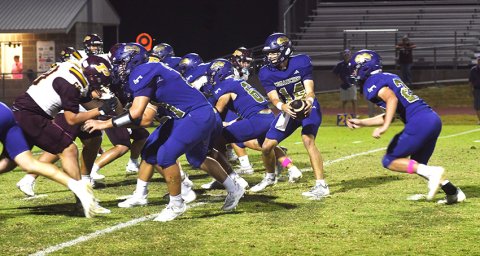 Quarterback Jake Simper eyes the defense on a triple-option play as running back Jace Cadell heads toward the handoff point.  Photo by Mark Lube.