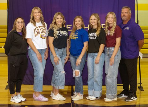 The Shiner Lady Comanche softball senior college signees: Addy Siegel (second from left), Lauren Springfield (third from left), Hailey Radicke (middle), Kara Kupka (third from right) and Kloe Polasek (second from right). Also shown are Shiner assistant coach Anastacia Rehak (left) and head coach Jason Keller (right). Photo courtesy of Photos by Lori Raabe.