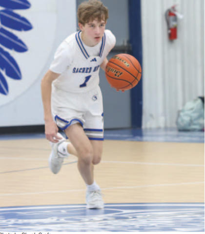 Photo by Chuck Grafe Freshman Colson Dworsky pushes the ball up court in the Faith Academy game.