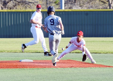 CJ Fogle (left) and Andy Nunez (right) attempt to prevent Bulverde Bracken’s Luke Fountain (middle) from a successful steal of second base March 23 at the Shiner Starplex. Photo by Mark Lube.