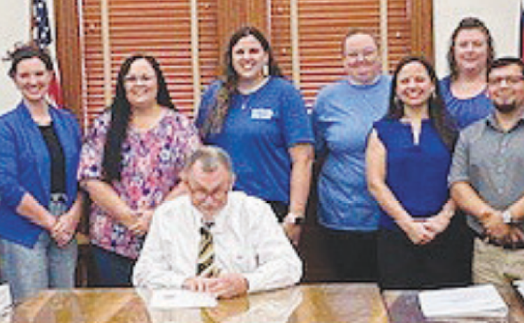 Members of SJRC Texas-Belong receive a proclamation from DeWitt County Commissioners declaring April 2024 as National Child Abuse Prevention Month. DeWitt County Judge Daryl Fowler, center, signs the proclamation at the March 25 meeting.