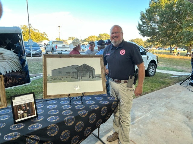 Pictured is Moulton Police Chief Daniel Beyer posing in front of the unveiling of the new police department.