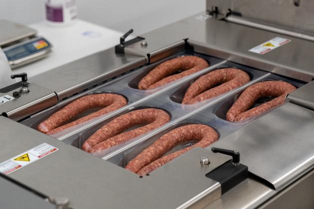 Speaking of packaging, this machine slides a single sheet of plastic down, heats it just to make six large bubble impressions that the sausages are slid into and sealed, ready for boxing and travel to the store locations.