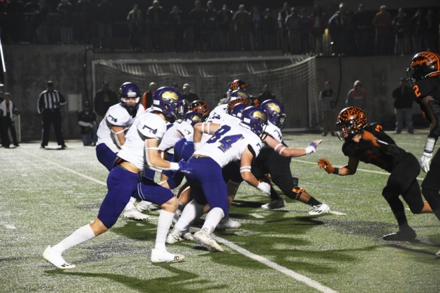 The Comanches offensive line fires off quickly at the snap Friday night against Refugio. Photo by Mark Lube.