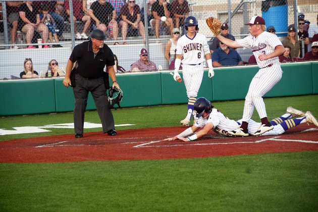 Kaiden Boothe slides into home to take advantage of a passed ball in the first game and score the Shiner’s first run. Boothe had three hits and scored twice in that game. Photo by Mark Lube.
