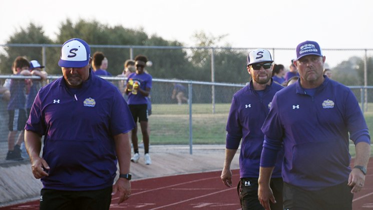 Shiner footballl coaches, from left, Jason Keller, Connor Stefka and Daniel Boedeker walk towards the Shiner sideline before the start of the home game against Hallettsville on Friday. Photo by Mark Lube.
