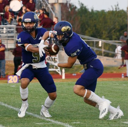Quarterback Carson Schuette “hands” the ball to running back Rakin Wallace at the mesh point of a triple-option play. Schuette ended up running the ball himself on the play. Photo by Mark Lube.