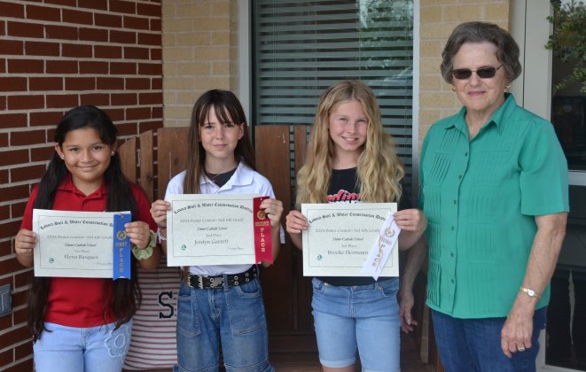 Lavaca Soil and Water Conservation District 13 selected its school wide 3rd–6th poster winners from Shiner Catholic School, who include from left Elana Basquez (1st), Jesslyn Garrett (2nd), Brooke Hermann (3rd) and LSWCD secretary, Dorothy Henke. Photo by Jimmy Appelt