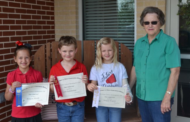 Lavaca Soil and Water Conservation District 13 selected its school wide K-2nd poster winners from Shiner Catholic School, who include from left Bridgette Woods (1st), Cade Halliburton (2nd), Teagan Wagner (3rd) and LSWCD secretary, Dorothy Henke. Photo by Jimmy Appelt
