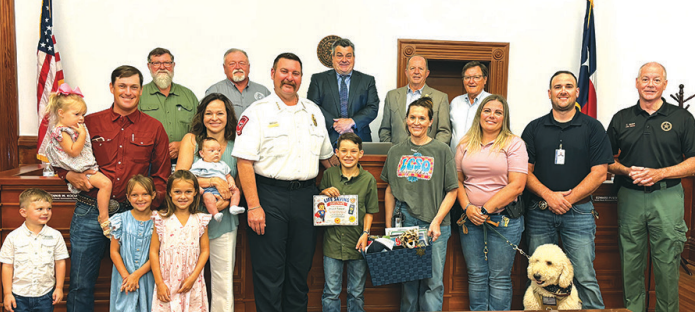 At Monday’s Lavaca County Commissioner’s Court meeting, Wyatt Kaspar was recognized with the Junior Life Saver Award for the actions he took in contacting the EMS during a medical emergency occurring at his home. Wyatt, 10-years old, stands next to Lavaca County EMS Michael Furrh (center of photo), who presented the award. Kaspar is surrounded by family, Lavaca County Sheriff’s Office personnel and the Commissioners’ Court. Photo by Tim Decker