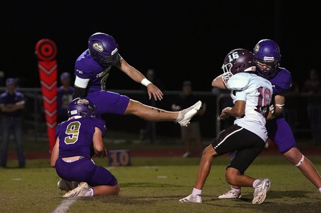 Comanche kicker Bode Werner attempts a PAT while younger brother Levi Werner is the holder during Shiner’s 54-0 win over Flatonia Friday night at Comanche Stadium. (Photos by Lori Raabe)