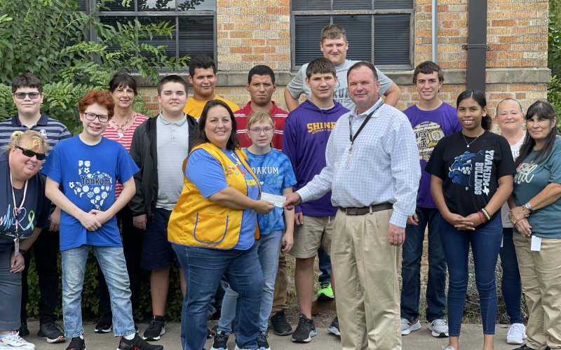 Shiner Lions Club’s Meagan Moore (front left) presents DLSEC Executive Director Jason Appelt (front right) with a donation as part of their annual support in front of Mrs. Thiry’s students and staff. Contributed Photo