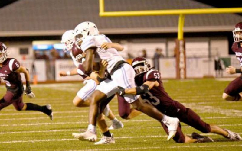 Defensive end Austin Lala tackles Warriors’ John Kelly for a first period loss. Chuck Grafe/Tribune-Herald