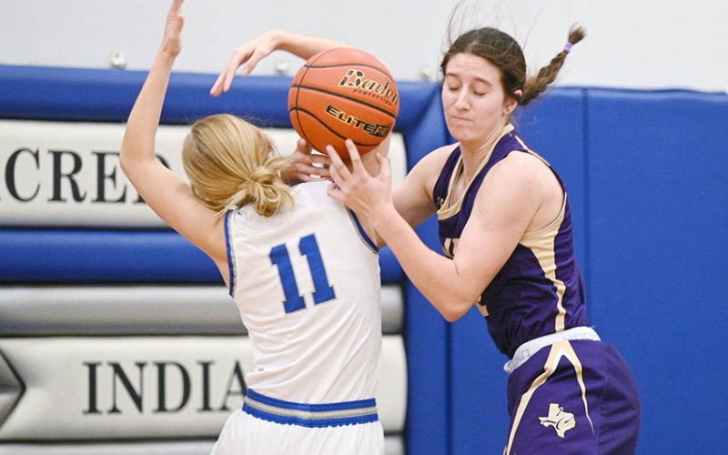 Shiner’s Rylee Vancura (right) tries to fend off Sacred Heart player Addison Ferry Jan. 2 in Hallettsville. Vancura scored six points as Shiner rolled to a 49-8 win. Photo by Chuck Grafe/Hallettsville Tribune-Herald.