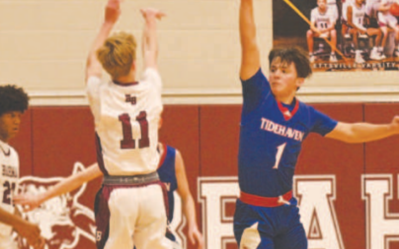 Despite good defense by Tidehaven’s Kale Russell, Shane Migura squeezes off a three. Chuck Grafe/Tribune-Herald