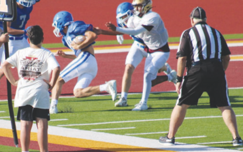 Clayton Haas, with the aid of a block by Ty Noska, scores the only touchdown in the scrimmage. Lisa Noska for the Tribune-Herald