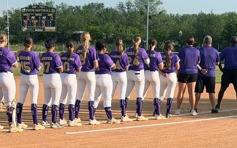 The Shiner Junior softball players and coaches/managers stand for the national anthem. Photo courtesy of Amanda Ulcak.