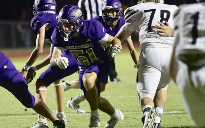 Offensive lineman Luke Dierlam provides some blocking as Levi Werner gets set to pitch the ball. Photo by Louann Heinsohn.