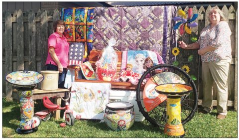 Moulton Easter Picnic auction chairpersons Lorrie Janecek and Mary Lou Dierschke display some of the fine items available Sunday at St. Joseph’s Social Center, part of the Catholic church’s annual Easter picnic in Moulton.