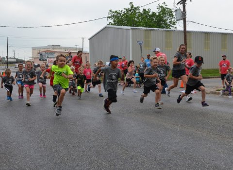 A mob of kids sprint to start the kid’s fun run on Saturday, May 7.