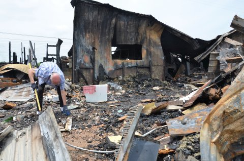  Joe F. Chandler Sr. scavenges the remains of the antique shop that he had managed for over ten years in search of salvageable items.