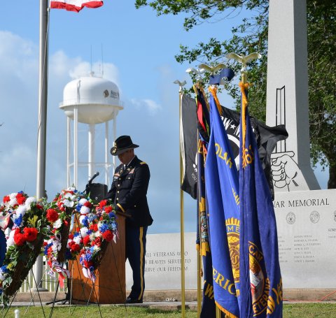 Operations Officer for the First Squadron, 112th Cavalry Regiment, Major Matt Machacek, pays his respects to fallen veterans during the Memorial Day Tribute at the Veterans War Memorial. 