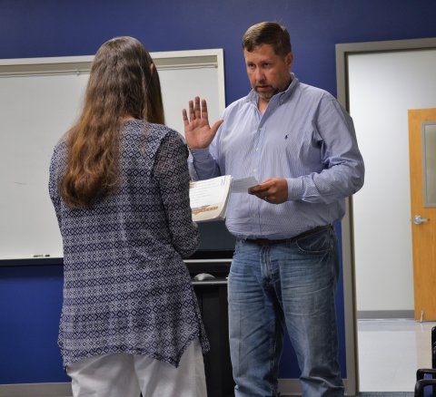 Rodney Svec repeats the oath of office administered by Paula Janota at the June 13 meeting at the YISD Administration Building.