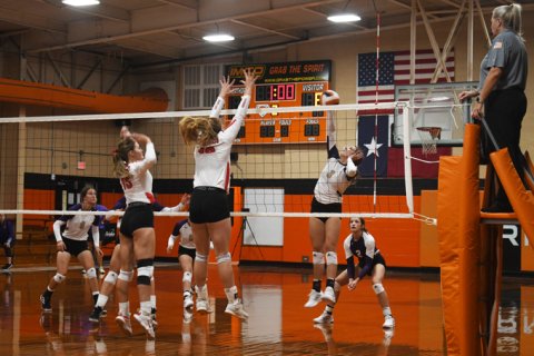 Columbus attempts to block a kill attempt by Chesney Machacek Thursday in the Schulenburg Tournament. Photo by Mark Lube.
