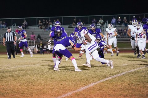 Carson Schuette starts a tackle with Beck Bishop and Dalton Brooks looking on. Photo courtesy of Photos By Lori Raabe.