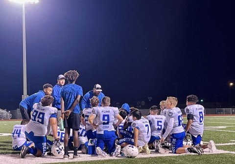Yoakum YFL coaches discuss adjustments with the 12U Bulldog football team during halftime Nov. 5.  Photo by Hans Lammeman