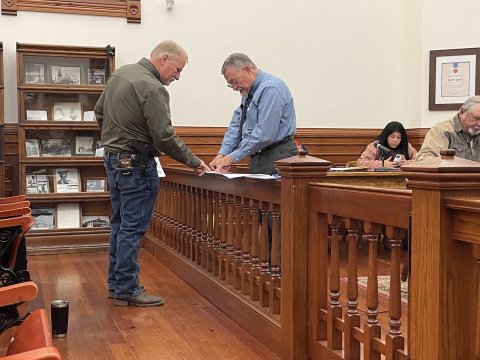 (L-R) Sheriff Carl Bowen and County Judge Daryl Fowler inspect an agreement at last Monday’s commissioners court meeting.