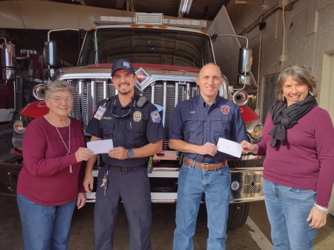 Wied member, Mary Pustka presents check to Shiner VFD representative, Tim Decker. Fire Chief, Steven Grahmann of Hallettsville VFD receives check from Wied vice president, Diane Aschen.