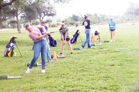Lady Comanches golfers from left Bri Sofka, Grace Migl, Megan Winkenwerder, Chelsea Whiddon, Morgan Lenehan and Lauren Faldyn practice at the range at Green-Dickson Park Monday afternoon in preparation for next week’s state golf tournament. Photo by Mark Lube.