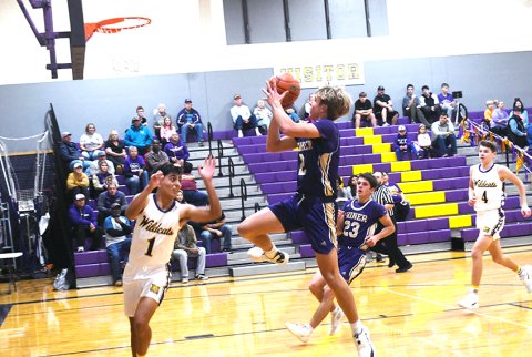 Bode Werner leaps to the bucket during action in the second half of the Comanches’ district game at Weimar Dec. 19. Werner deposited 12 points for second-place scorer in Shiner’s 50-42 win over the Wildcats to even their district record at 1-1. Photo by Mark Lube.