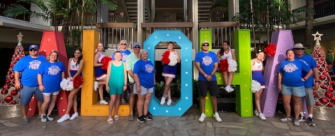 Above, the Moulton cheerleaders pose with their parents and sponsors in front of the Aloha State sign in Hawaii. And at left, starting top row from left, cheerleaders attending the Pearl Harbor Day parade performance were Valeria Pinedo, Abygail Tinajero and Abigail Siegal, and bottom from left, Katie Richter and Samantha Michal.