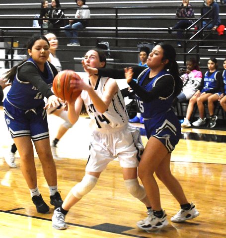 Addison Simper tries to position for a shot while between two defenders. Photo by Mark Lube.