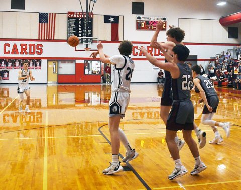acing some serious attention in the paint, Tyler Siegel kicks the ball out to Trent Meisetschleager Feb. 27 against Fayetteville. Photo by Mark Lube.