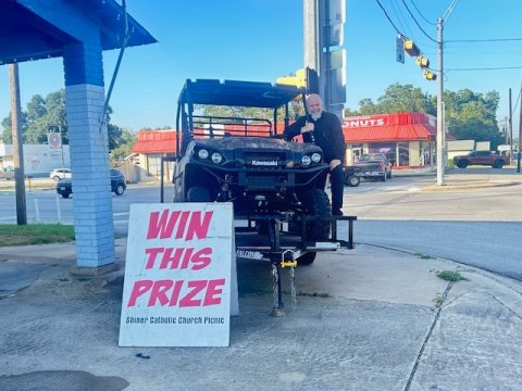 Father Bryan Heyer is shown with the first place raffle prize, a 2024 Kawasaki Mule Pro FXT. This mule includes a 12 ft. utility trailer, generously donated by Boehm Tractor Sales. Photo by Clayton Kelley.