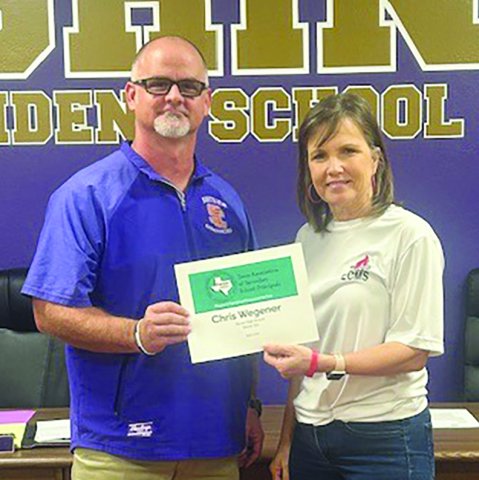 Sandy Nesser, a representative from Region III, hands Chris Wegener the award for High School Principal of the Year for Region III. Photo by Clayton Kelley.