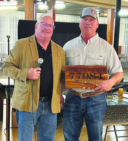Board Chairman Mike Campbell, left, presents the Citizen of the Year award to Billy Petru, right.