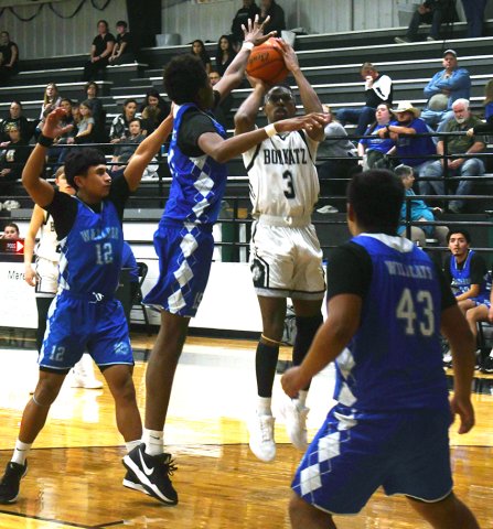 Waelder players try to contest a Ja’Michaels Williams’s shot. He chipped in 16 points. Photo by Mark Lube.