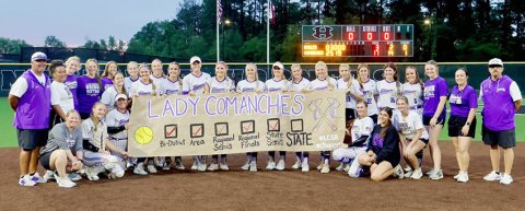 The Shiner softball team poses for a photo with their custom-made banner after defeating Como-Pickton 17-3 in game three of the state semifinals-series. Shiner plays Sundown Thursday (May 28) at 1 p.m. in the Class 2ADII state final. Photo courtesy of Louann Heinsohn.