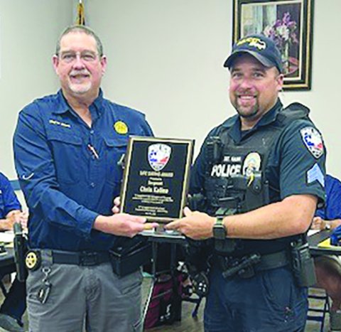 Sgt. Chris Kalina, right, was recognized for saving a woman from a house fire that occurred in early April. Police Chief Wayne Denson presents him with a plaque. Not pictured is Officer William Miller, who assisted in that call. Photo by Clayton Kelley.
