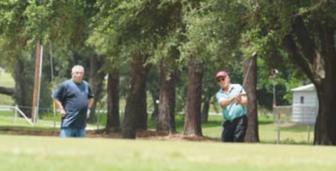 Gary Appelt chips onto the green on No. 9 Saturday as Virgil Gutierrez looks on.