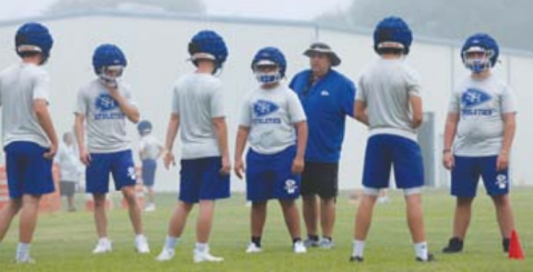 Photo by Chuck Grafe Head coach Rodney works with linemen during the first workout Monday morning.