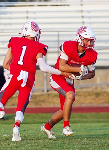 Birthday boy Jack Ehrig (right) secures a handoff from Tyler Pendley during St. Paul’s win over Bloomington on Friday night.  (Photos by Lori Raabe) 