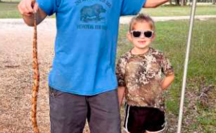Not all heroes wear capes… some carry a shovel. The Bippert family marks copperhead number nine in Lavaca County while his princess proudly (and safely) looks on. Photo submitted by Tracie Bippert